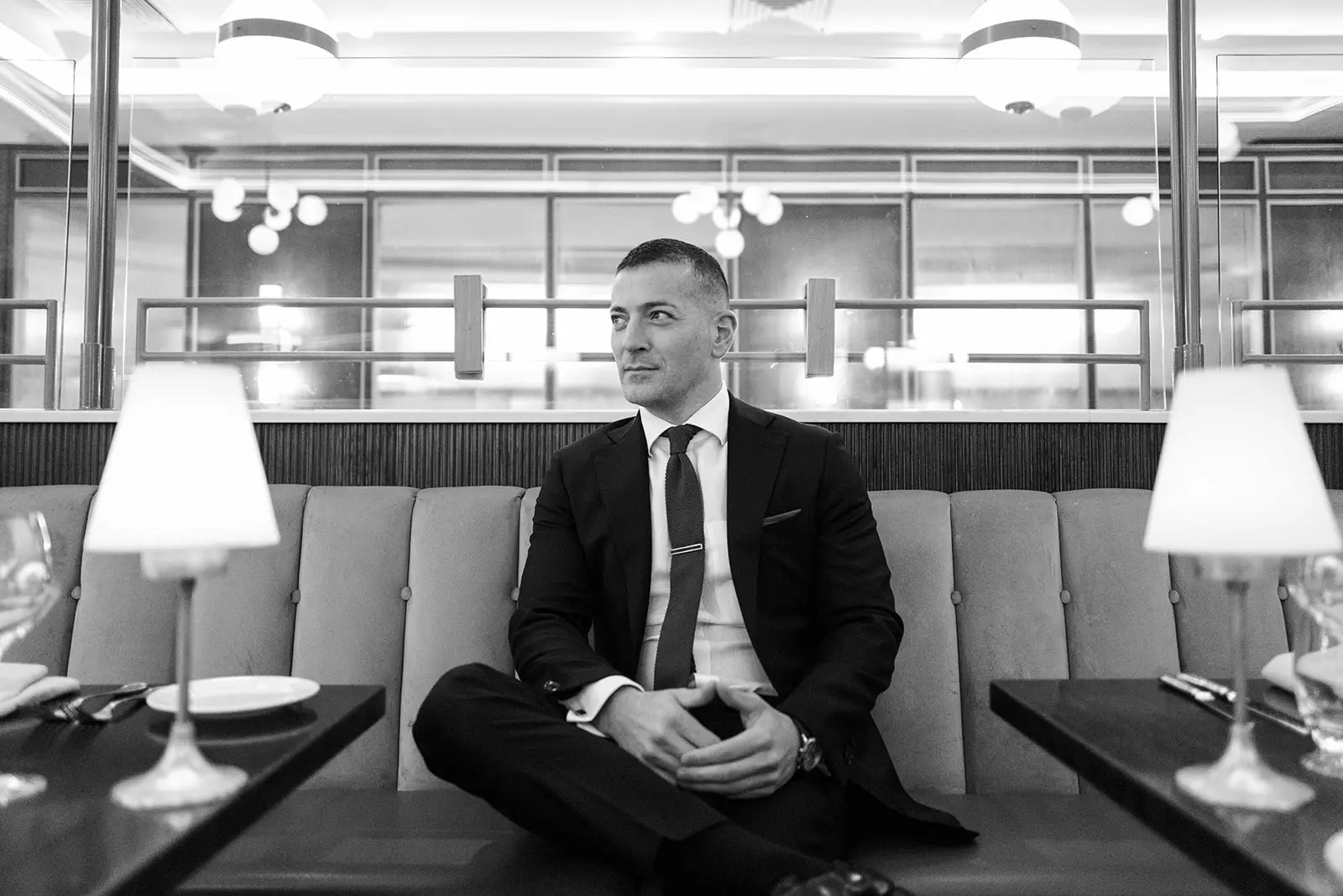 Shane Black, professional mentalist and magician in Ireland, seated in a stylish venue wearing a suit – available for corporate events, weddings, and private parties.